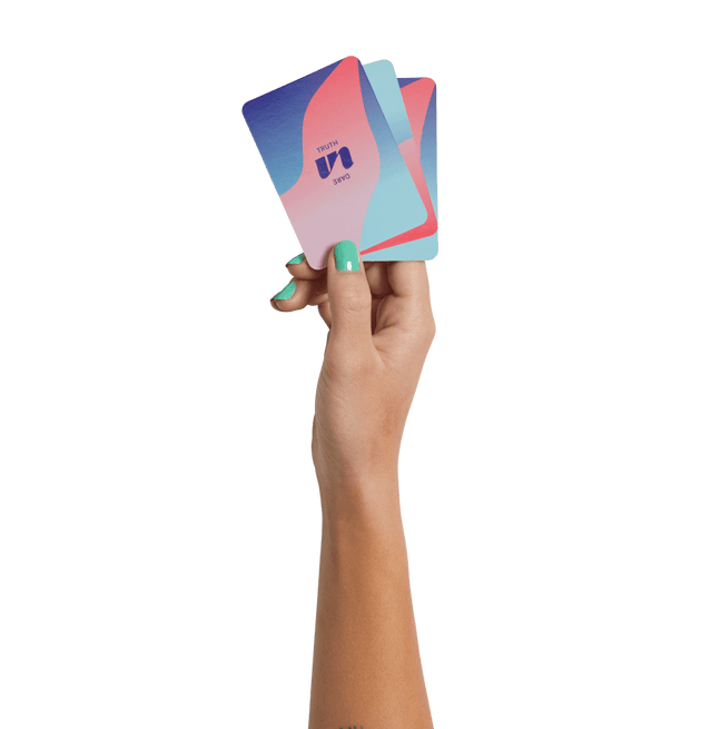 Hand holding Truth or Dare Cards with a mix of blue and pink design